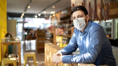Male business owner and PPP loan recipient wearing a face mask