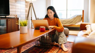 Woman working on laptop testing her financial IQ. 