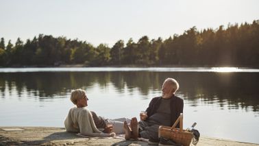 Couple having a picnic by a lake and discussing how does an annuity work.