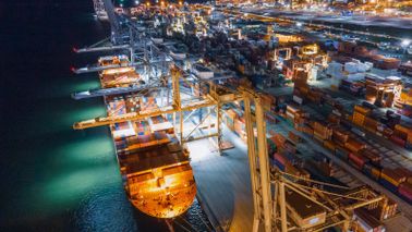 Cargo ship being unloaded in a harbor.