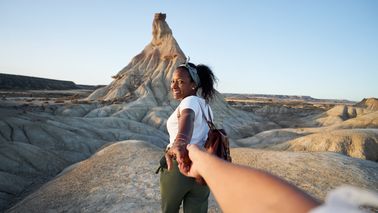 couple in the mountains after making their travel dollar go further