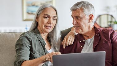 People work on a computer and consider Social Security in their budget.