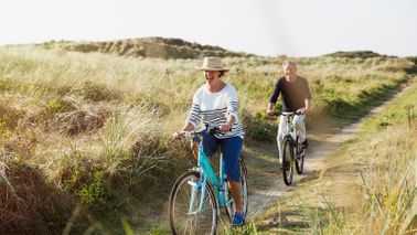 couple riding bikes in an open field