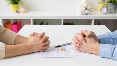 A man and woman negotiate their divorce at a table