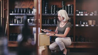 Woman kneeling down and looking at her small business financial wellness checklist.