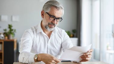 man reading letter at home