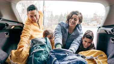 family loading car before going to road trip destination