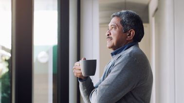 Man drinking a cup of coffee while noodling on the economic insights shared in this edition of Northwestern Mutual’s weekly market commentary.