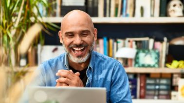 Man looking at a laptop and smiling
