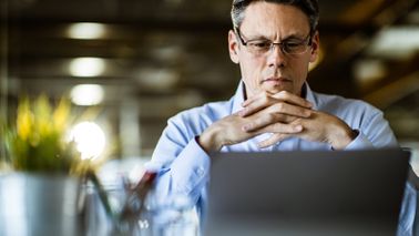 Man reading Northwestern Mutual Market Commentary on his computer