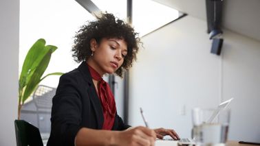 Woman at a desk reading Northwestern Mutual Market Commentary
