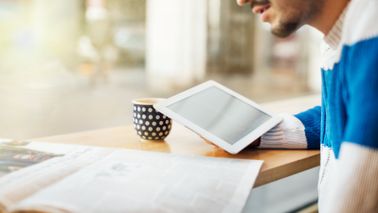 Man drinking coffee while reading Northwestern Mutual Market Commentary for May 24, 2021