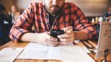 Man on his phone looking up how to create a monthly budget