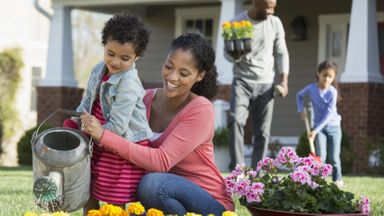family with supplemental homeowners insurance watering flowers