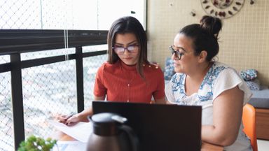 mother and daughter at a desk researching what a private student loans