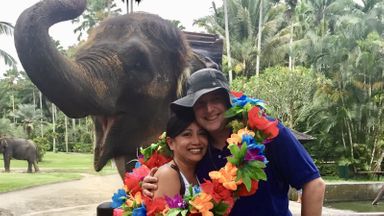 Financial planner and her husband posing by an elephant