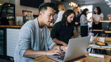 man working on laptop in cafe