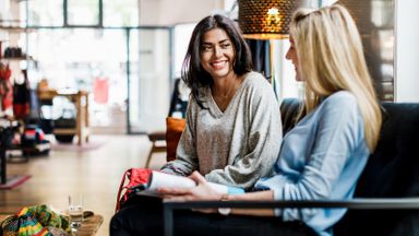 Women sitting on a bench talking about finances