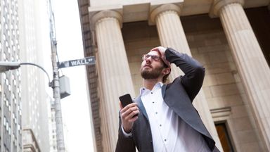 Man upset after checking market news on his phone.