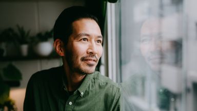Man looking out the window thinking about world events.
