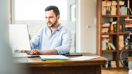young man working at computer at home